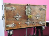 a wooden chest sitting on top of a table in front of a pink wall