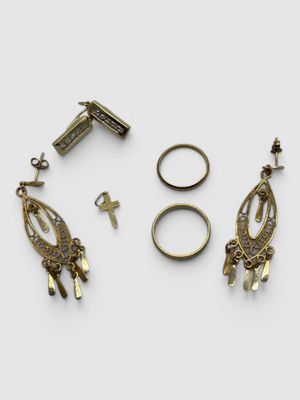 three pairs of earrings and a ring are shown on a white surface