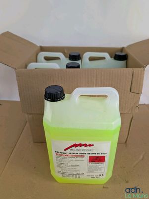 a bottle of liquid sitting in a box on the floor