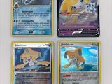 quatre cartes Pokémon différentes posées sur une surface blanche : l'une représente un chat, l'autre un chien