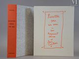 un livre orange posé à côté d'un livre blanc sur lequel figurent des inscriptions