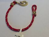 un bracelet en cordon rouge muni d'un fermoir doré