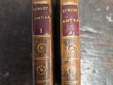 une paire de livres anciens reliés en cuir posés sur une table en bois
