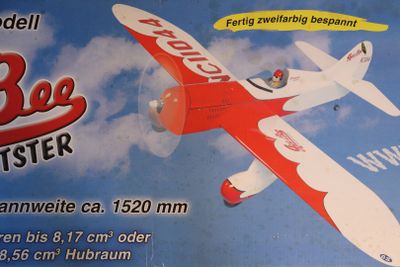 a red and white toy airplane with a blue sky in the background