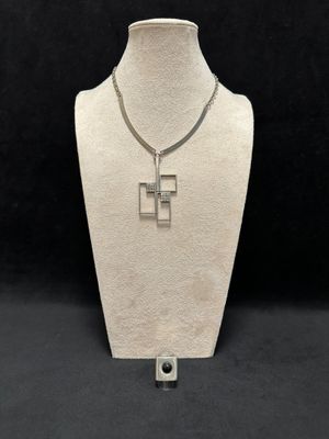 a white mannequin with a silver cross on it