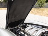 a silver car with its hood open on the street