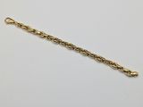 a gold chain bracelet with a ball clasp on a white background