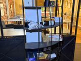 a black shelf with various items on it in a room