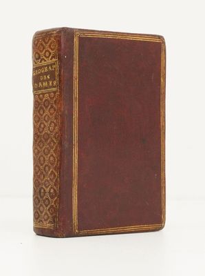 un vieux livre à la couverture brune posé sur une surface blanche