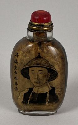 a small glass bottle with a picture of a woman on it