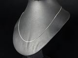une photo en noir et blanc d'un collier en argent porté par un mannequin