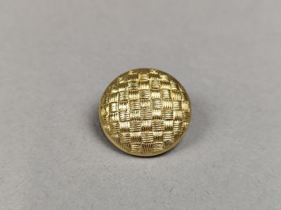 a close up of a gold button on a white surface