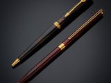 a pair of fountain pens on a black background