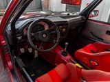 the interior of a red car with red seats and a steering wheel
