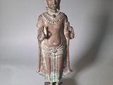 statue d'un homme coiffé d'un chapeau et vêtu d'une robe, posée sur un socle en bois