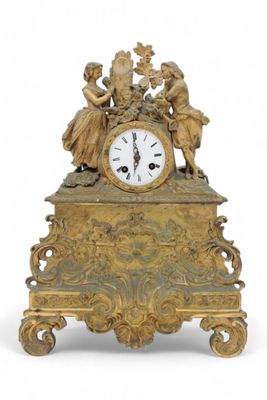a gold clock with angels on top of it