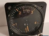 a black clock with a yellow face on a white table