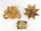 two gold brooches and a coin on a white surface
