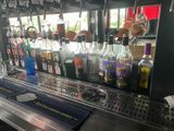 bottles of alcohol are lined up on the bar at a restaurant