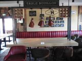 une table et des chaises dans un restaurant, avec une enseigne accrochée au mur