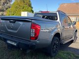 the back of a silver pick up truck parked on the side of a road