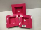 three pink boxes that are sitting on a table