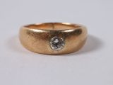 a close up of a gold ring with a diamond on it