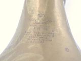 a gold vase with a black handle on a white background