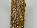 a close up of a gold colored tie on a white surface