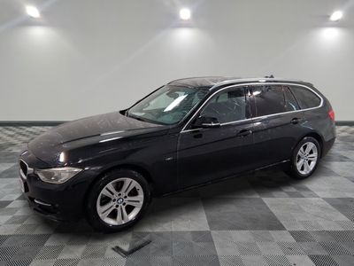 une photo d'un break BMW noir sur un sol à damier