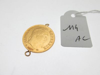 un gros plan d'une pièce d'or à laquelle est attachée une étiquette