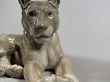 porcelain figurine of a lion laying down on a white surface