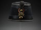 un chapeau noir orné d'une décoration dorée sur le dessus