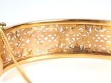 gold plated bracelet with a chain on a white surface