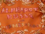an orange scarf with a picture of a horse on it