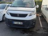 une camionnette blanche garée dans un parking à côté d'une camionnette blanche