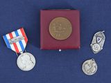 trois médailles et une médaille posée sur une surface bleue