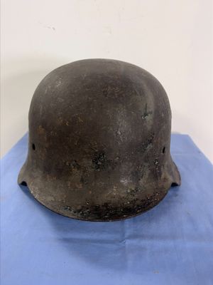 an old helmet on a blue cloth on a white surface