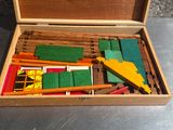 une boîte en bois remplie de crayons de couleur et de gommes de différentes couleurs