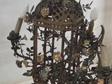 wrought iron chandelier with flowers and birds hanging from it ' s sides