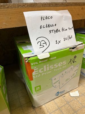 Des paquets de papier toilette sont empilés les uns sur les autres par terre