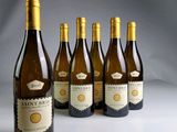 six bouteilles de vin sont alignées sur une table
