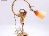 une image représentant une lampe posée sur une table, sur laquelle est perché un oiseau