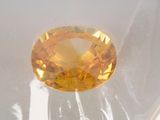 an oval cut yellow sapphire sitting on top of a white surface