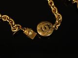 a close up of a gold chain with a coin on it