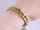 a close up of a person ' s hand wearing a gold bracelet