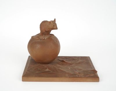 a sculpture of a mouse sitting on top of a ball