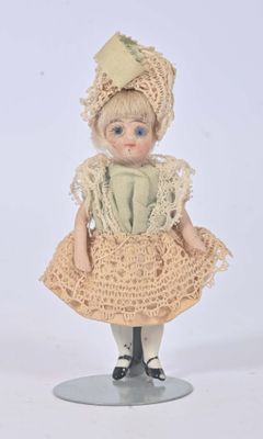 a small doll that is wearing a dress and a hat