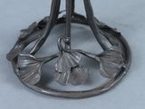 a metal object with leaves on it on a table