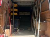a van that is parked in a garage with tools in the back
